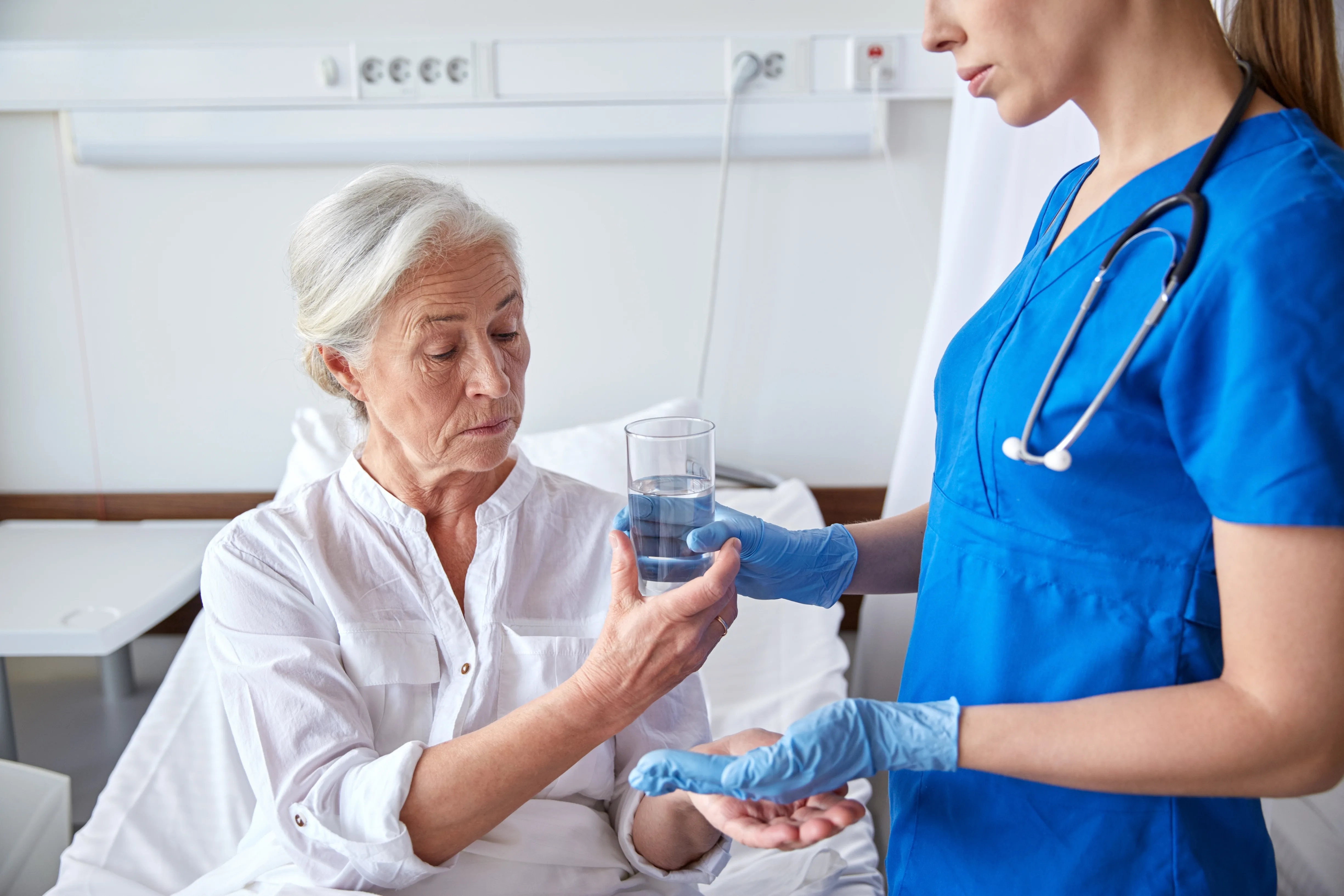 Nurse assisting an elderly patient with medication